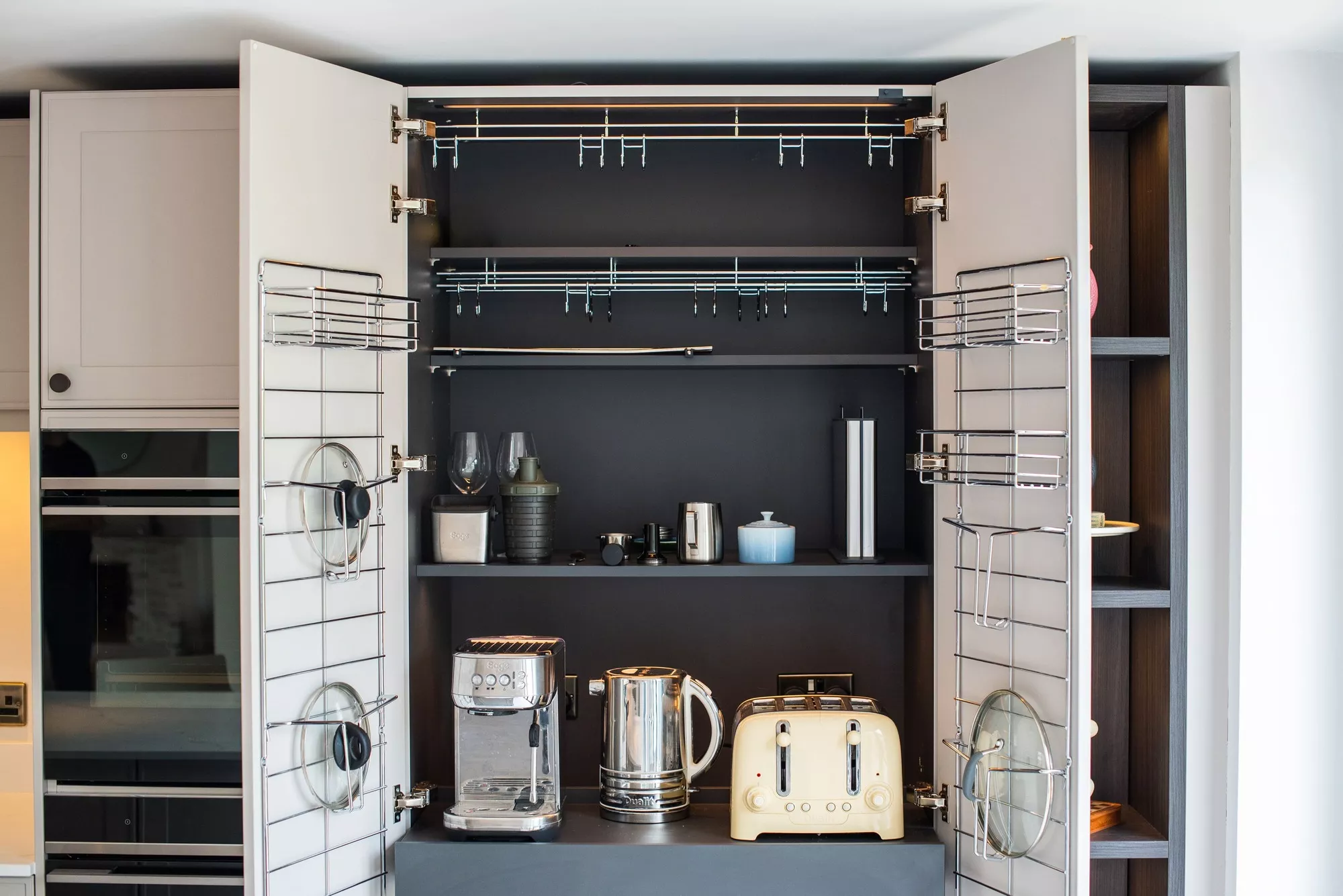 Kitchen breakfast pantry with open cabinet doors, internal shelving and appliance storage