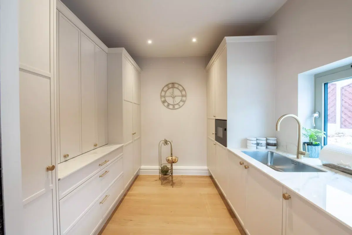 Bespoke kitchen cabinetry with soft ambient lighting and under cabinet illumination in neutral space