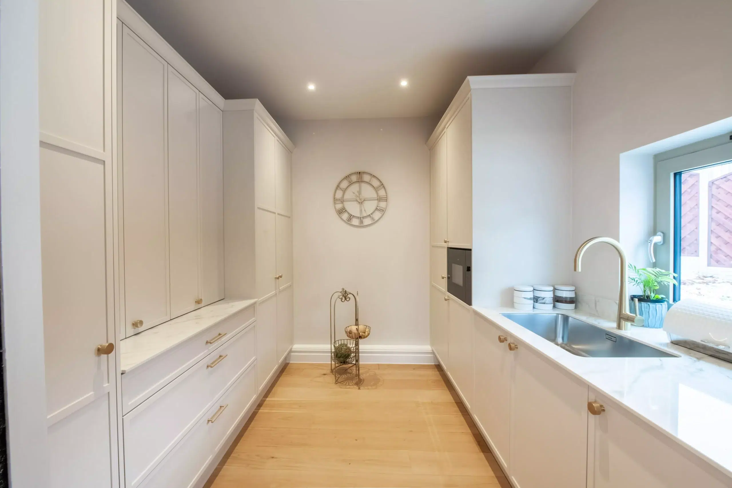 Bespoke kitchen cabinetry with soft ambient lighting and under cabinet illumination in neutral space