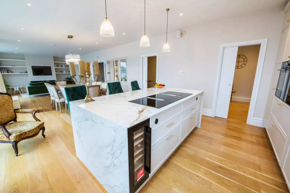 Open plan kitchen with marble island and pendant lighting creating layered ambient and task lighting