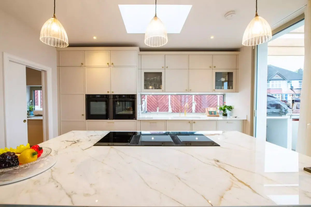 Contemporary shaker kitchen with marble worktop, pendant lighting and built-in appliances by Ornate Kitchens